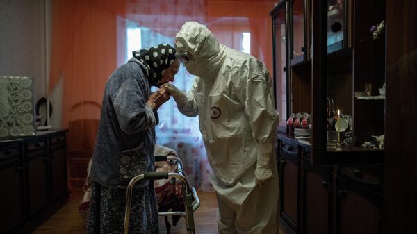 Священник отец Иоанн навещает 81-летнюю Анну Одинокову, страдающую от Covid-19, в ее доме в Москве, Россия