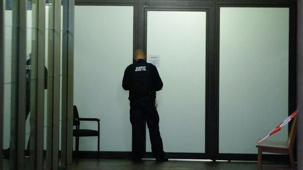 Сотрудник службы безопасности суда перед началом процесса по делу об убийстве гражданина Грузии в парке Тиргартен