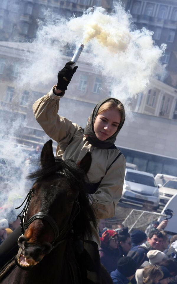 Девушка с дымовой шашкой на коне во время празднования Масленицы во Владивостоке