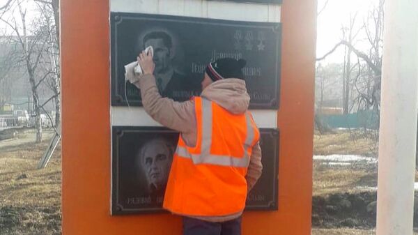 Сотрудник МКУ Управление благоустройства г. Артема очищает портреты героев Великой Отечественной войны на стеле 