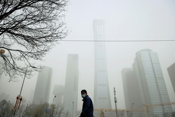 Мужчина во время песчаной бури в Пекине