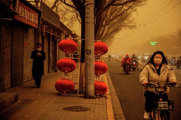 Люди во время песчаной бури в Пекине