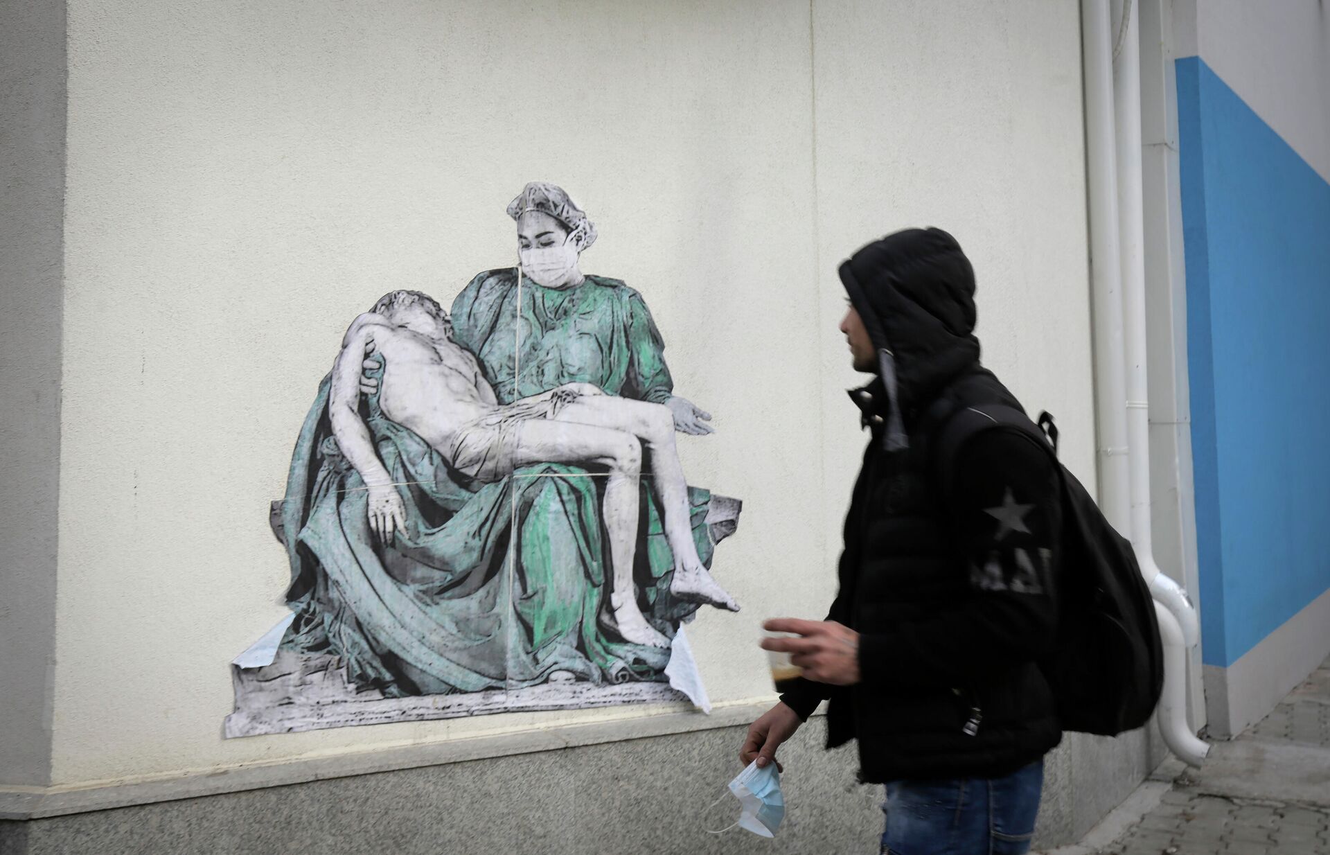 Мужчина проходит мимо копии Пьеты Микеланджело, нарисованной на стене больницы Пирогова в Софии, Болгария - РИА Новости, 1920, 15.03.2021