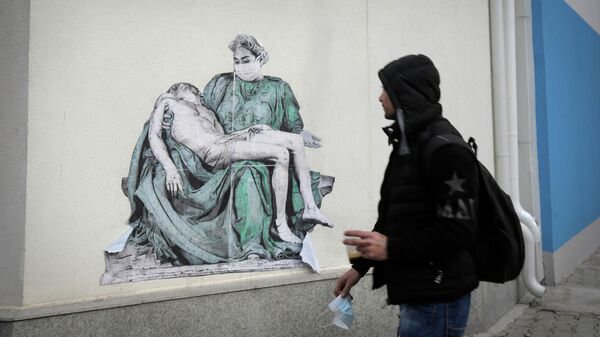 Мужчина проходит мимо копии Пьеты Микеланджело, нарисованной на стене больницы Пирогова в Софии, Болгария