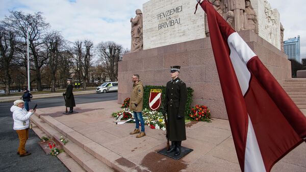 Сторонники латышского легиона Waffen-SS возлагают цветы к памятнику Свободы в Риге