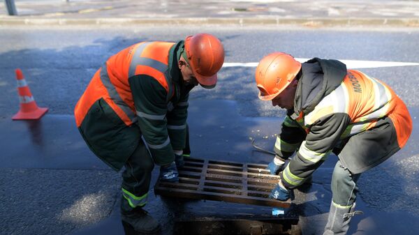Сотрудники ЖКХ ведут работы по очистке от мусора ливневой канализации в Москве