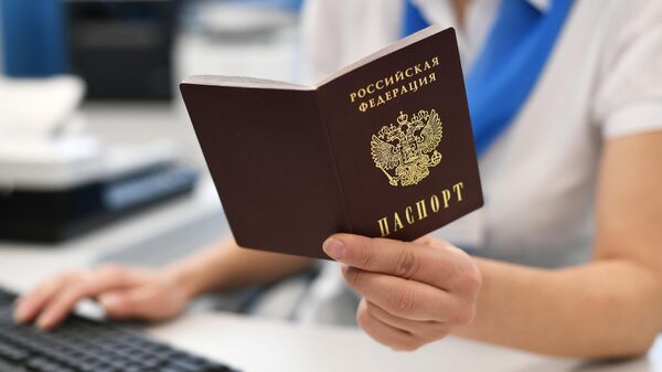 Сотрудник пенсионного фонда держит в руках паспорт РФ