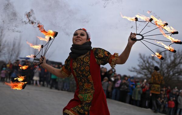 Участница фаер-шоу выступает на праздновании Масленицы в Долине Лефкадия в Краснодарском крае