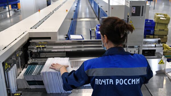 Сотрудница на линии сортировки писем в логистическом почтовом центре Почты России 