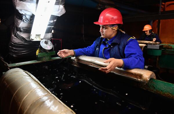 Работница демонстрирует руки перед камерой видеонаблюдения на изумрудоизвлекательной фабрике Мариинского изумрудного прииска в Свердловской области