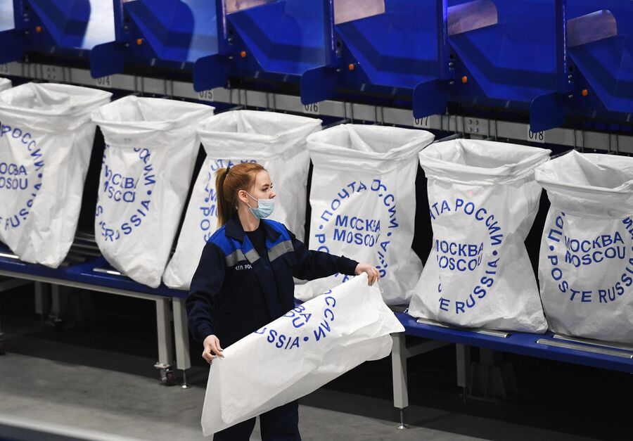Сотрудница на линии сортировки мелких посылок и пакетов в логистическом почтовом центре Почты России в Новосибирской области