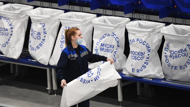 Сотрудница на линии сортировки мелких посылок и пакетов в логистическом почтовом центре Почты России в Новосибирской области