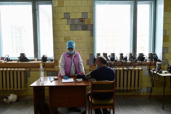 Медицинская сестра измеряет артериальное давление у шахтера перед спуском в шахту Мариинского изумрудного прииска в Свердловской области