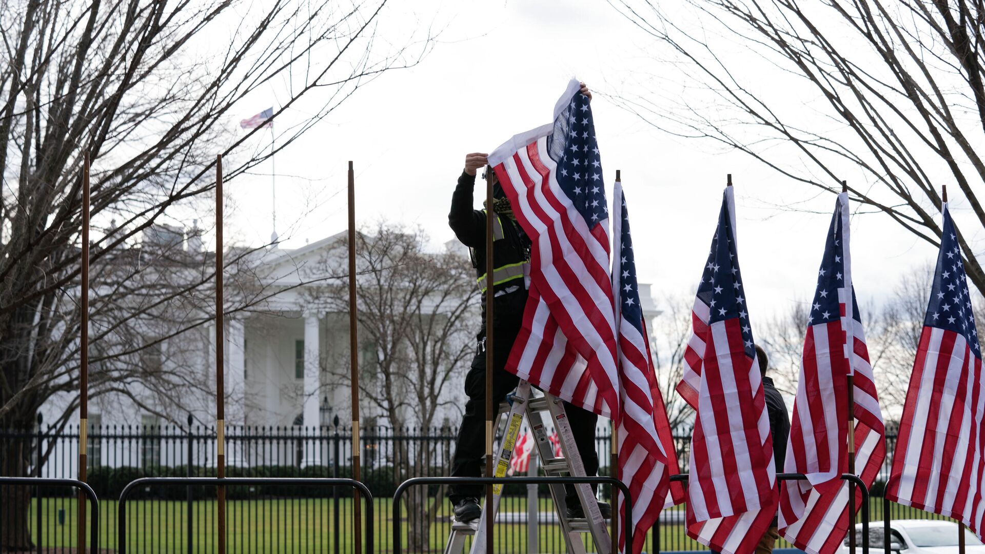 Рабочий устанавливает флаги возле Белого дома в Вашингтоне - РИА Новости, 1920, 18.04.2021