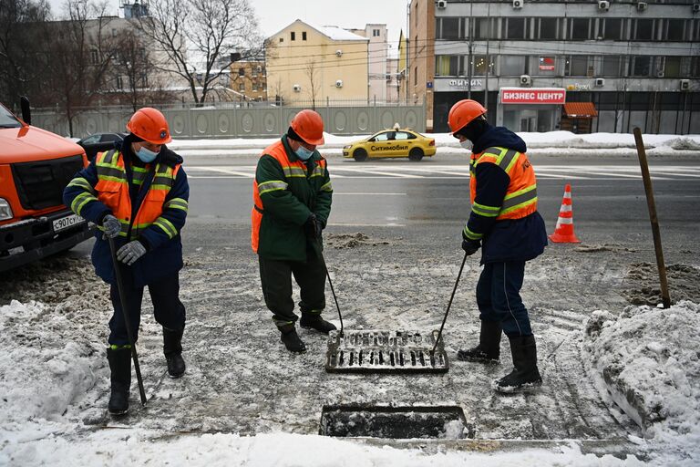 Сотрудники ГУП Мосводосток во время очистки водоприемных колодцев в Москве