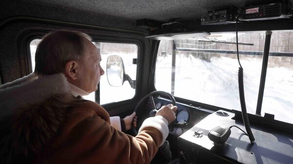 Президент РФ Владимир Путин управляет вездеходом во время прогулки в тайге