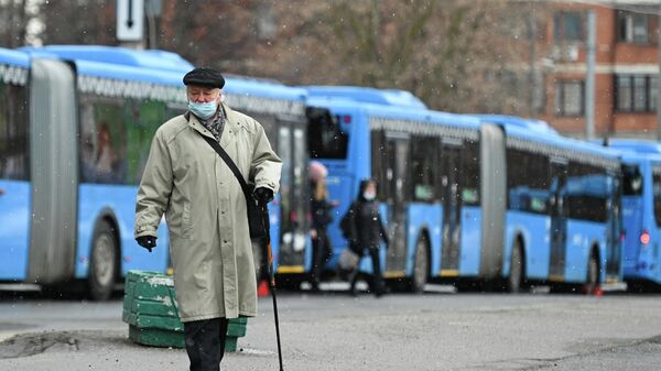 Пожилой мужчина на остановке бесплатных автобусов КМ у станции метро Беляево