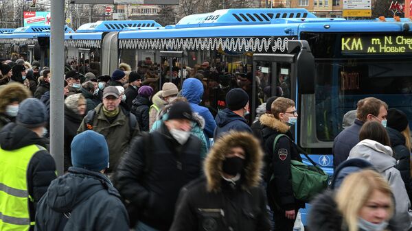 Пассажиры на остановке бесплатных автобусов КМ у станции метро Беляево