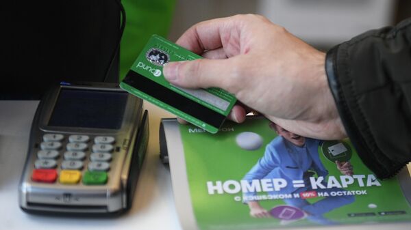 Посетитель расплачивается банковской картой в салоне сотовой связи