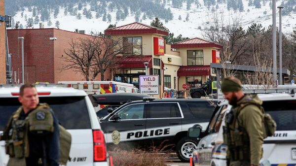 Сотрудники правоохранительных органов стоят по периметру места стрельбы в продуктовом магазине King Soopers в Боулдере, штат Колорадо, США