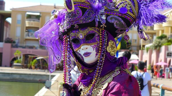 Артист в карнавальной маске в Венеции
