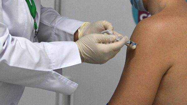 Мужчина вакцинируется от COVID-19 российской вакциной Спутник V (Гам-КОВИД-Вак) в мобильном пункте вакцинации в торговом центре Ереван Плаза в Москве