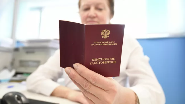 Сотрудник ПФР держит в руках пенсионное удостоверение
