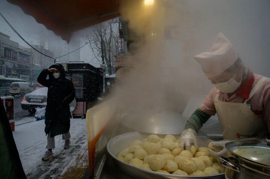 Уличный торговец готовит дамплинги в Сеуле, Южная Корея 