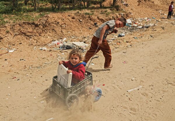 Палестинские дети играют рядом в городе Газа