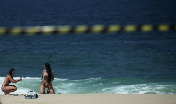 Девушки фотографируются на пляже в Рио-де-Жанейро, Бразилия 