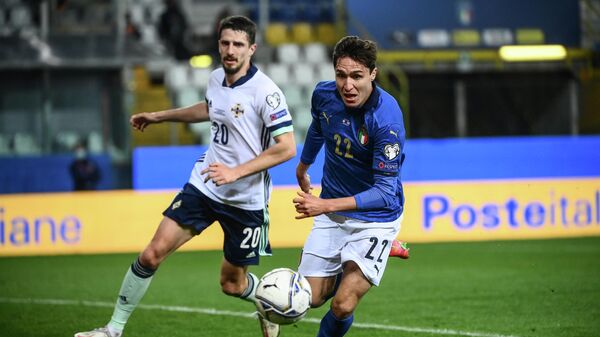 Italy's forward Federico Chiesa (R) outruns Northern Ireland's defender Craig Cathcart to go for a goal opportunity during the FIFA World Cup Qatar 2022 Group C qualification football match between Italy and Northern Ireland on March 25, 2021 at the Ennio-Tardini stadium in Parma. (Photo by Marco BERTORELLO / AFP)