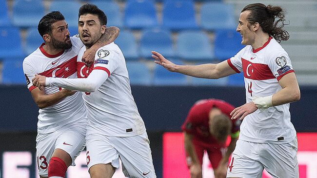 Turkey's midfielder Ozan Tufan (C) celebrates with defenders Umut Meras (L) and Caglar Soyuncu after scoring a goal during the FIFA World Cup Qatar 2022 qualification football match between Norway and Turkey at La Rosaleda stadium in Malaga on March 27, 2021. (Photo by JORGE GUERRERO / AFP)