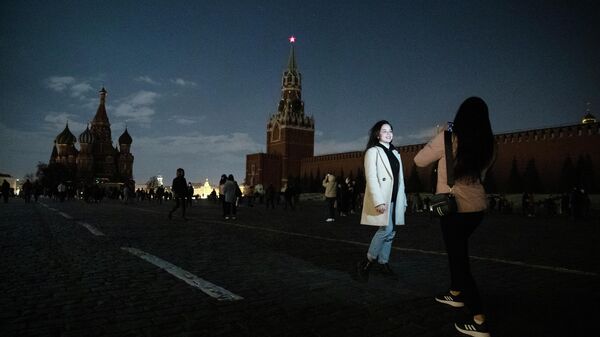 Девушки фотографируются на Красной площади в Москве во время экологической акции Час Земли