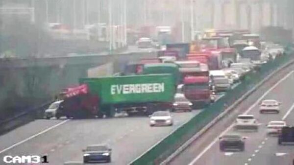 Грузовик фирмы Evergreen на автомагистрали в Китае. Кадр с камеры видеонаблюдения