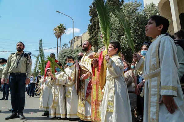 Люди празднуют Пальмовое воскресенье у церкви в Дамаске, Сирия
