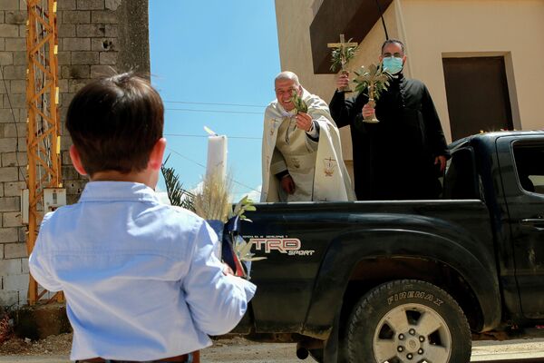 Священник посещает районы в Южном Ливане, чтобы благословить верующих во время Пальмового воскресенья