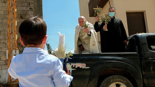 Священник посещает районы в Южном Ливане, чтобы благословить верующих во время Пальмового воскресенья