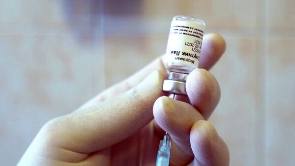 Медицинский работник держит контейнер с вакциной Спутник Лайт во время клинических исследований