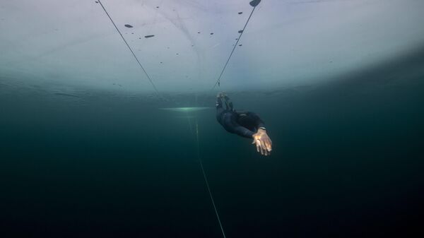 Французский фридайвер Артур Гарен-Боэри во время тренировки рекордного заплыва подо льдом в Финляндии