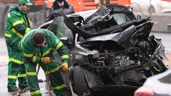 Сотрудники службы эвакуации грузят пострадавший в ДТП автомобиль на Смоленской площади в Москве.