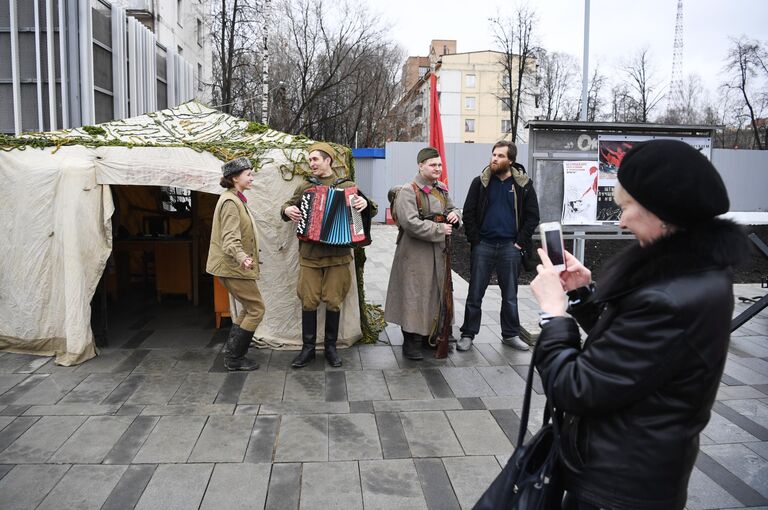 Женщина фотографирует артистов у станции Народное ополчение Большой кольцевой линии московского метрополитена.