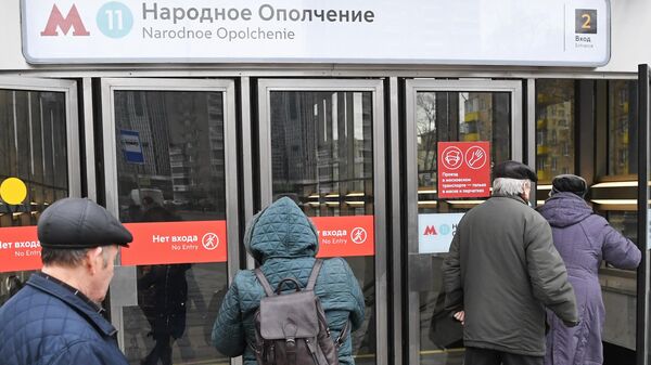 Люди заходят в вестибюль станции Народное ополчение Большой кольцевой линии московского метрополитена