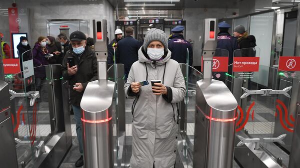 Пассажиры проходят через турникеты на станции Народное ополчение Большой кольцевой линии московского метрополитена