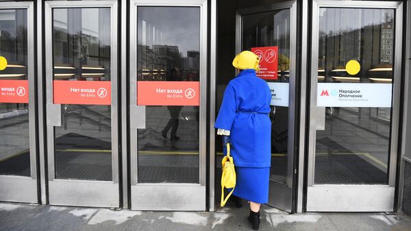 Женщина заходит в вестибюль станции Народное ополчение Большой кольцевой линии московского метрополитена