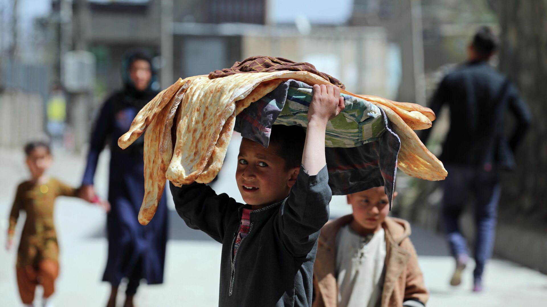 Афганский мальчик несет хлеб в Кабуле - РИА Новости, 1920, 12.11.2021