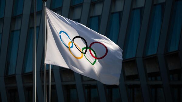 A picture taken on March 8, 2021 in Lausanne shows the Olympic flag floating next to the headquarters of the International Olympic Committee (IOC) ahead of a session of the World's sport governing body held virtually. (Photo by Fabrice COFFRINI / AFP)