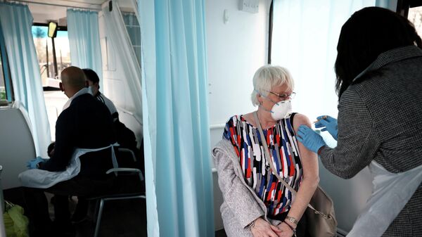 Женщина получает дозу вакцины AstraZeneca COVID-19 в Лондоне, Великобритания