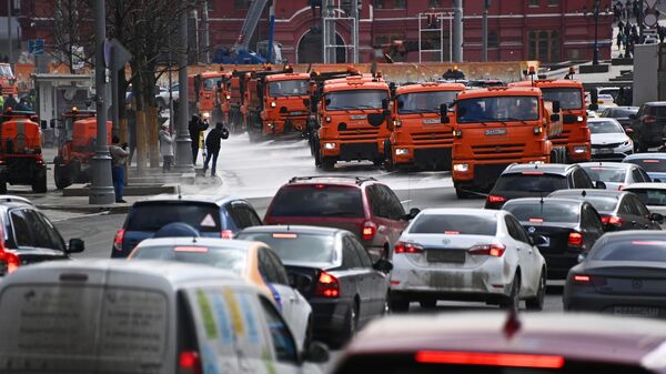 Автомобили коммунальной службы производят мытье асфальтового покрытия на Тверской улице в Москве