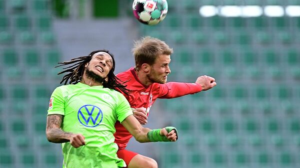 Wolfsburg's Swiss defender Kevin Mbabu (L) ansd Cologne's Swedish forward Sebastian Andersson vie for the ball during the German first division Bundesliga football match between VfL Wolfsburg and 1 FC Cologne in Wolfsburg, northern Germany, on April 3, 2021. (Photo by Tobias SCHWARZ / various sources / AFP) / DFL REGULATIONS PROHIBIT ANY USE OF PHOTOGRAPHS AS IMAGE SEQUENCES AND/OR QUASI-VIDEO