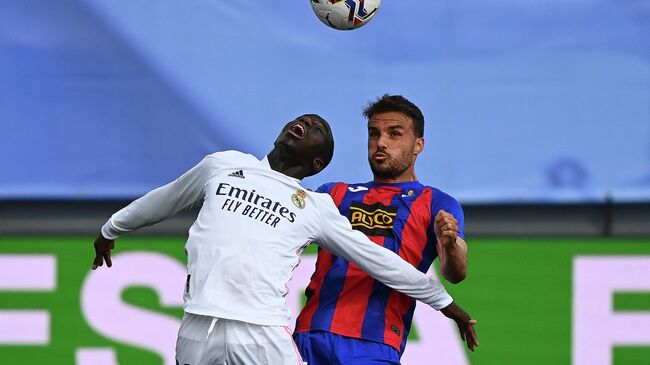 Real Madrid's French defender Ferland Mendy (L) heads the ball with Eibar's Spanish midfielder Pedro Leon during the Spanish League football match between Real Madrid CF and SD Eibar at the Alfredo di Stefano stadium in Valdebebas on the outskirts of Madrid on April 3, 2021. (Photo by GABRIEL BOUYS / AFP)